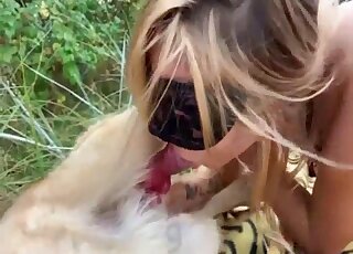 Masked blonde treats her pet dog with a blowjob outdoors
